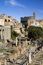 View of The Forum with the Colosseum rising behind the bell tower of the church of Santa Francesca Romana with tourists and the Temple of Antoninus and Faustina the Temple of Romulus and the Basilica...