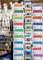 Display of guide books to the city in different languages on a souvenir stall beside small statues and other goodsEuropean Italia Italian Roma Southern Europe Holidaymakers Tourism Tourist