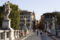 Tourists on the Ponte Sant Angelo bridge over the River Tiber lined with statues of winged angelsEuropean Italia Italian Roma Southern Europe History Holidaymakers Religion Religious Tourism