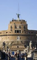 Castel Sant Angelo with tourists on the Ponte Sant Angelo bridge over the River Tiber lined with statues of winged angelsEuropean Italia Italian Roma Southern Europe History Holidaymakers Tourism
