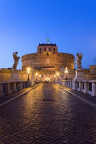 Castel Sant Angelo illuminated at night with tourists on the Ponte Sant Angelo bridge over the River Tiber lined with statues of winged angelsEuropean Italia Italian Roma Southern Europe History Holi...