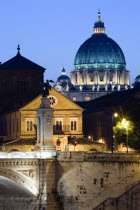 The Dome of the Basilica of St Peter in the Vatican City illuminated at night with the Ponte Vittorio Emmanuel II bridge across the River Tiber in the foregroundEuropean Italia Italian Roma Southern...