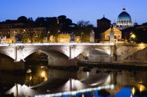 The Dome of the Basilica of St Peter in the Vatican City illuminated at night with the Ponte Vittorio Emmanuel II bridge across the River Tiber in the foregroundEuropean Italia Italian Roma Southern...