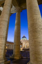 Vatican City The Basilica of St Peter and the square or Piazza San Pietro illuminated at night seen through the columns of BerniniEuropean Italia Italian Roma Southern Europe Catholic Principality Ci...