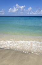 Empty beach at Hillsborough with waves from the aquamarine sea breaking on the shorelineBeaches Resort Sand Sandy Scenic Seaside Shore Tourism West Indies Caribbean Grenadian Greneda Beaches Resort...