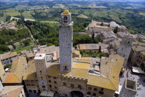 View of the Palazzo Vecchio del Podesta of 1239 with its medieval tower in the Piazza del Duomo with rooftops and Tuscan farmland on the slopes of the hill townEuropean Italia Italian Southern Europe...