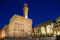 Piazza della Signoria The Palazzo Vecchio and Campanile belltower beside the Loggia dei Lanzi at night with people walking in the squareEuropean Italia Italian Southern Europe Toscana Tuscan Firenze...