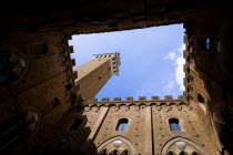 A view looking up within the inner courtyard of the Palazzo Publico town hall looking up to the campanile belltower or Torre del Mangia in the Piazza del CampoEuropean Italia Italian Southern Europe...