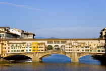 The early evening sunlight on the Ponte Vecchio Old Bridge across the River Arno busy with touristsEuropean Italia Italian Southern Europe Toscana Tuscan Firenze History Holidaymakers Tourism Warm Li...