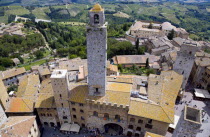 View of the Palazzo Vecchio del Podesta of 1239 with its medieval tower in the Piazza del Duomo with rooftops and Tuscan farmland on the slopes of the hill townEuropean Italia Italian Southern Europe...