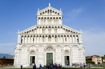 The Campo dei Miracoli or Field of Miracles.The lombard style 12th Century facade of the Duomo Cathedral with tourists at the base under a blue skyEuropean Italia Italian Southern Europe Toscana Tusc...