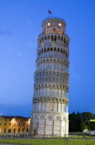 Campo dei Miracoli or Field of Miracles The Leaning Tower belltower or Torre Pendente illumunated at dusk with tourist walking at the baseEuropean Italia Italian Southern Europe Toscana Tuscan Histor...