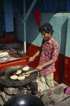 Cooking breads outside restaurant.Asia Asian Bangladeshi One individual Solo Lone Solitary Asia Asian Bangladeshi One individual Solo Lone Solitary