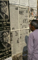 Man reading wall mounted newspaper.Asia Asian Bangladeshi Dacca Male Men Guy One individual Solo Lone Solitary Asia Asian Bangladeshi Dacca Male Men Guy One individual Solo Lone Solitary