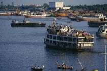Crowded steamer leaving the Sadarghat terminal for the south.  People camped under makeshift tents on top deck.Asia Asian Bangladeshi Dacca Southern Asia Asian Bangladeshi Dacca Southern