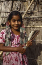 Portrait of young girl smiling holding writing slate. Asia Asian Bangladeshi Happy Immature Kids Learning Lessons One individual Solo Lone Solitary Teaching Asia Asian Bangladeshi Happy Immature Kid...