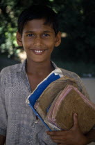 Portrait of boy holding school books.Asia Asian Bangladeshi Kids Learning Lessons One individual Solo Lone Solitary Teaching Asia Asian Bangladeshi Kids Learning Lessons One individual Solo Lone Sol...