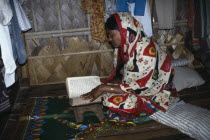 Woman reading the koran in home in slum area.Moslem Asia Asian Bangladeshi Female Women Girl Lady Islam Muslim One individual Solo Lone Solitary Quran Religion Religious Muslims Islam Islamic Shanty...