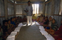 Teacher and pupils in village school.  Students sit on earth floor of corrugated metal hut. Asia Asian Bangladeshi Kids Learning Lessons Teaching Asia Asian Bangladeshi Kids Learning Lessons Teachin...