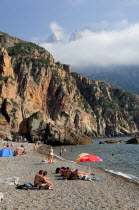 Plage De Bussaglia  sandy beach with sunbathers & umbrellas. Rocky cliffs & cloud on hillsPortrait Beaches Oporto Resort Seaside Shore Tourism Tourists Travel French Holidaymakers Western Europe Dest...