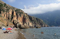 Plage De Bussaglia  sandy beach with sunbathers & umbrellas. Rocky cliffs & cloud on hillsBeaches Oporto Resort Seaside Shore Tourism Tourists Travel French Holidaymakers Western Europe Destination D...