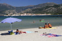 Bathers & sandy beach with St Florent old town in distanceBeaches Resort Seaside Shore Tourism French Western Europe European Sand Sandy Beach Tourism Seaside Shore Tourist Tourists Vacation Sand San...