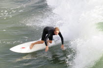Surfer riding waves at Manhattan BeachSouth Beaches American Destination Destinations North America Northern Resort Sand Sandy Seaside Shore Southern Tourism United States of America Gray LA One indi...