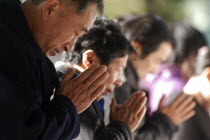 Jingumae - at Meijijingu shrine  line of New Years worshippers praying  in fore man over sixty years oldAsia Asian Japanese Nihon Nippon Male Men Guy Old Senior Aged Religion Religious