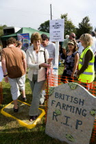 Findon village Sheep Fair People passing through a Bio Security point for hand wash and foot bath to prevent spread of foot and mouth with a sign on a mock gravestone reading British Farming RIP.Grea...