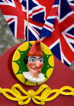 Findon village Sheep Fair Bright red Punch and Judy stand with Union Jack flags and a carved image of Punch.Great Britain Northern Europe UK United Kingdom British Isles European