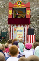Findon village Sheep Fair A group of children sitting on the ground watching a Punch and Judy glove puppet show.Great Britain Northern Europe UK United Kingdom British Isles European