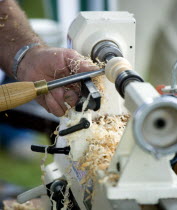 Findon village Sheep Fair Man using a wood lathe with a chisel cutting into the spinning wood.Great Britain Northern Europe UK United Kingdom British Isles European