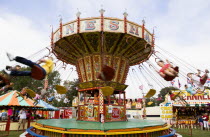 Findon village Sheep Fair Children in motion riding on a swing carousel.Great Britain Northern Europe UK United Kingdom British Isles European