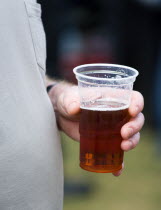 Findon village Sheep Fair Man with a fat stomach holding a plastic pint measure mug containing bitter beer in his left hand.Great Britain Northern Europe UK United Kingdom British Isles European