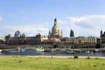 The city skyline with cruise boats moored on the River Elbe in front of the embankment buildings on the Bruhl Terrace busy with tourists of the Art Academy the Frauenkirche Church of Our Lady Dome wit...