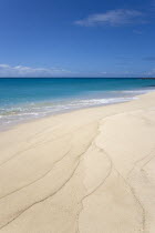 South Glossy Beach in Glossy Bay with waves breaking on the shoreline of the turqoise sea.Beaches Resort Sand Sandy Scenic Seaside Shore Tourism West Indies Caribbean Destination Destinations Salt Wa...