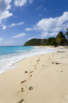 South Glossy Beach in Glossy bay with footprints in the sand and waves from the turqoise sea breaking on the shore.Beaches Caribbean Destination Destinations Resort Sand Sandy Scenic Seaside Shore To...