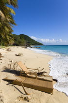 South Glossy Beach in Glossy bay with two damaged wooden sunbeds in the sand and waves from the turqoise sea breaking on the shore.Beaches Caribbean Destination Destinations Resort Sand Sandy Scenic...