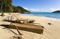 South Glossy Beach in Glossy bay with two damaged wooden sunbeds in the sand and waves from the turqoise sea breaking on the shore.Beaches Caribbean Destination Destinations Resort Sand Sandy Scenic...
