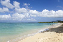 Waves breaking on Paradise Beach at LEsterre Bay with a fisherman beaching his boat and the turqoise sea and Sandy Island sand bar beyond.Beaches Caribbean Destination Destinations Grenadian Greneda...