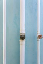 Three white pipes running down a turqoise painted wall in Clifton.Caribbean West Indies Windward Islands 3 Destination Destinations