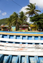 The fruit and vegetable market in Mulzac Square in the capital Clifton seen over a beached fishing boat.Caribbean West Indies Windward Islands Destination Destinations