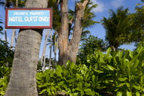 Sign attached to a coconut palm tree in the grounds of the Anchorage Yacht Club saying Private Property Hotel Guests Only.Caribbean West Indies Windward Islands Destination Destinations Signs Display...