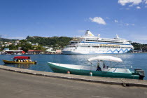 Cruise ship liner Aida Aura and local tourist boat moored on either side of the Carenage in the harbour with a full tourist boat approaching the dockside.Caribbean Destination Destinations Grenadian...
