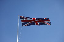 British Union Jack flag flying in wind against blue sky.European Great Britain Northern Europe UK United Kingdom British Isles