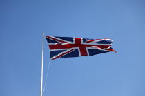 British Union Jack flag flying in wind against blue sky.European Great Britain Northern Europe UK United Kingdom British Isles