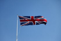 British Union Jack flag flying in wind against blue sky.European Great Britain Northern Europe UK United Kingdom British Isles