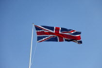 British Union Jack flag flying in wind against blue sky.European Great Britain Northern Europe UK United Kingdom British Isles
