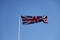 British Union Jack flag flying in wind against blue sky.European Great Britain Northern Europe UK United Kingdom British Isles