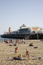 Sandy Beach and Pier with tourists sunbathing.Blue Destination Destinations European Great Britain Holidaymakers Immature Kids Northern Europe Sand Sandy Beaches Tourism Seaside Shore Tourist Tourist...